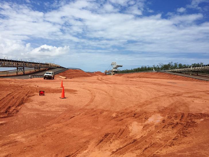 a truck drives down a dusty road at rio tinto's amrun bauxite mine in cape york